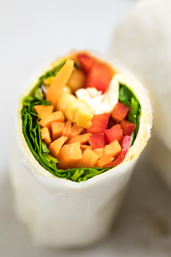 A halved easy 5 ingredient chickpea veggie wrap.