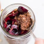 Vegan brownie overnight oats lifted with a spoon.