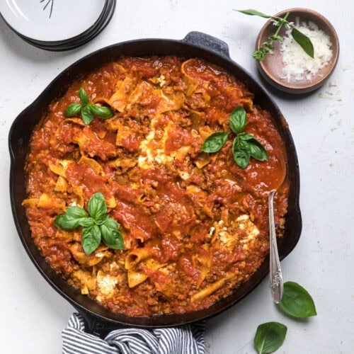 A black cast iron skillet with easy vegan skillet lasagna inside.