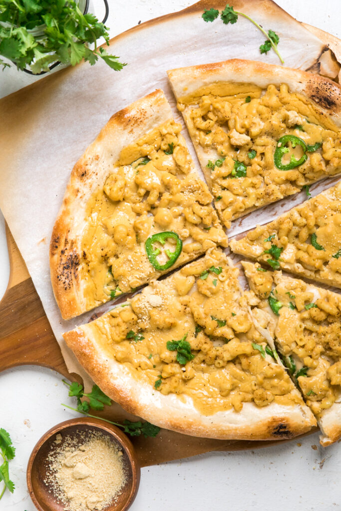 Spicy vegan mac and cheese pizza on a table.