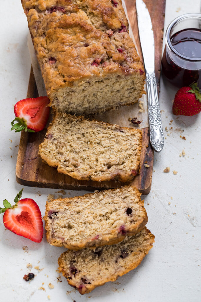 A loaf of Vegan strawberry banana bread with two slices cut.