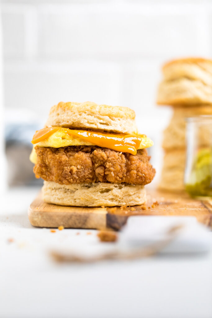 A single copycat Chick-fil-A vegan chicken biscuit on a wooden board. 
