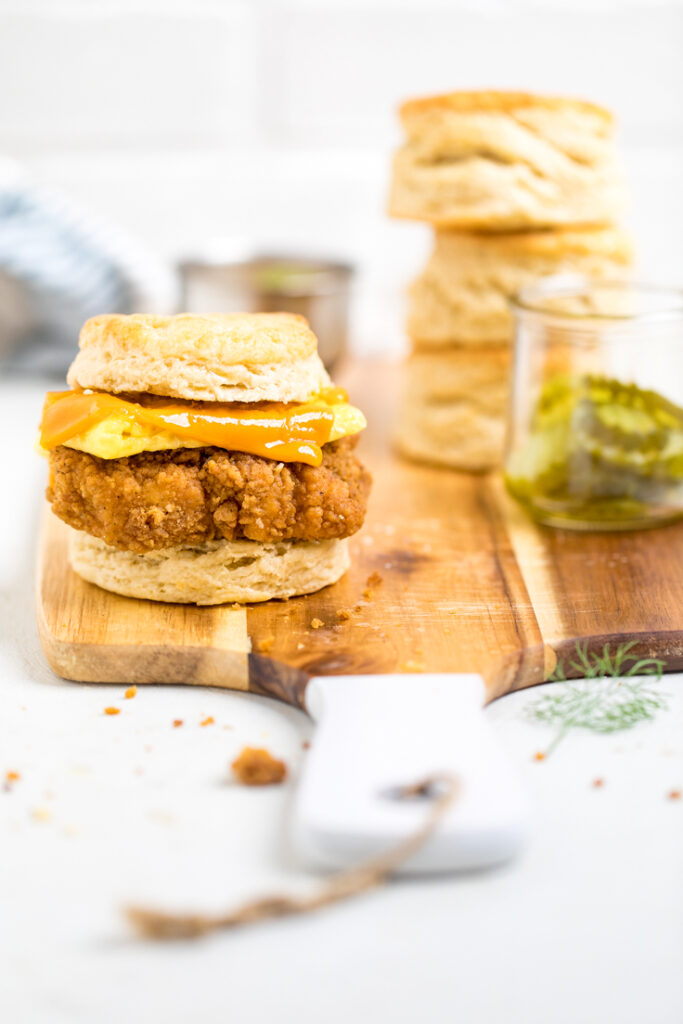A Copycat Chick-fil-a Vegan Chicken biscuit sandwich on a cutting board.