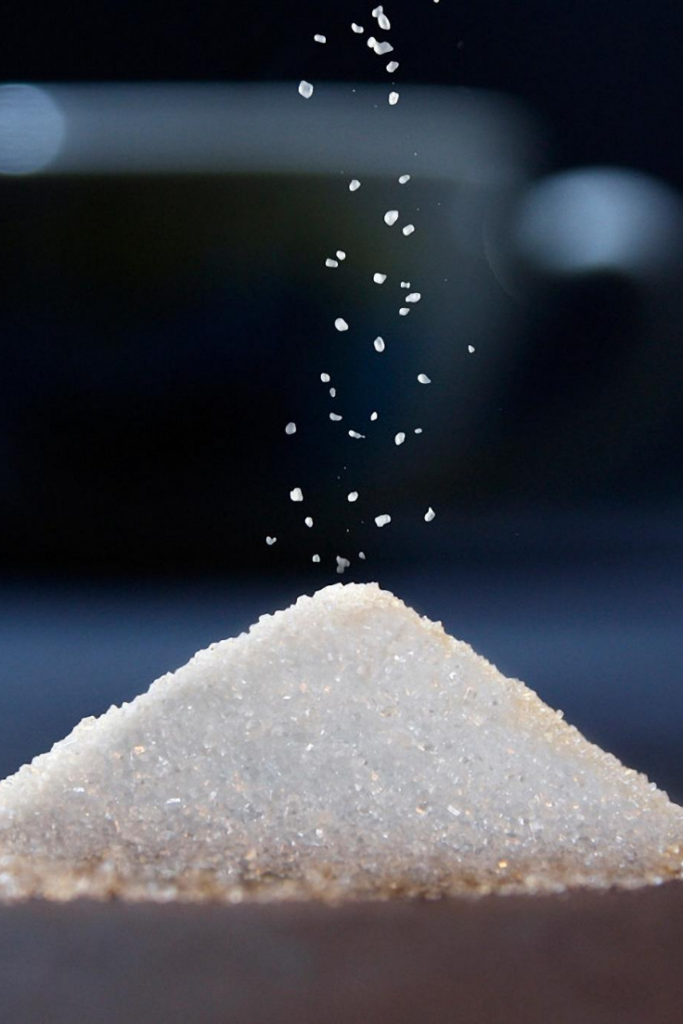 A pile of Sugar with some sprinkled from the top.