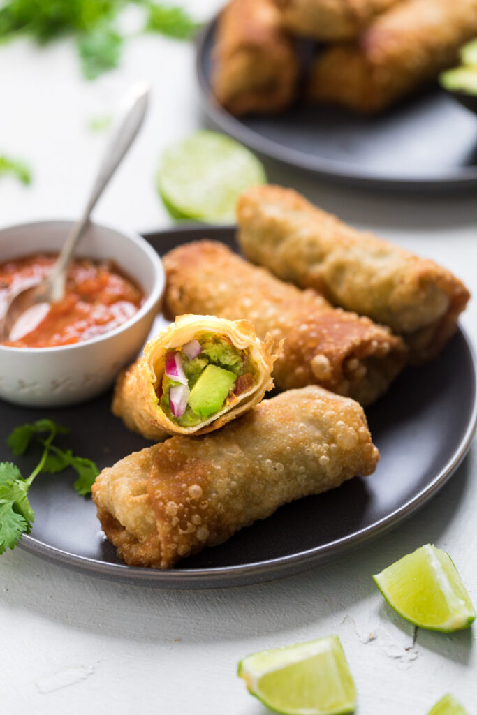 A plate of vegan avocado Egg Rolls with a side of salsa. 