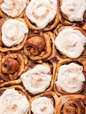 Tops of Vegan Apple Pie Cinnamon Rolls with Cream Cheese Spice Frosting.