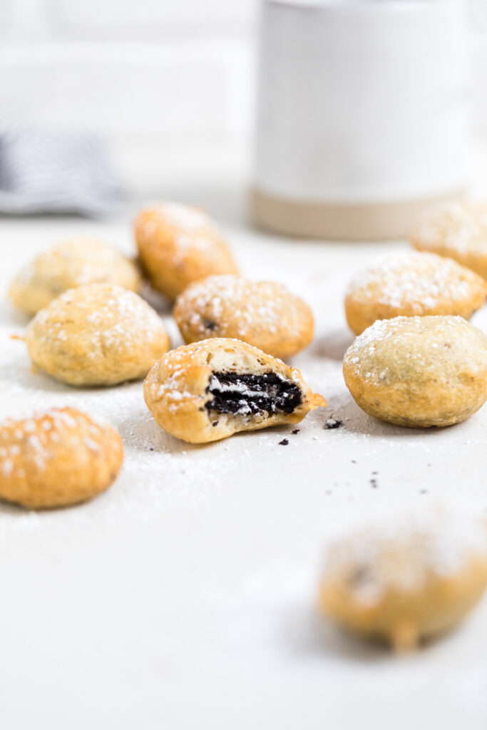 Vegan fried oreos on a table with one bitten. 