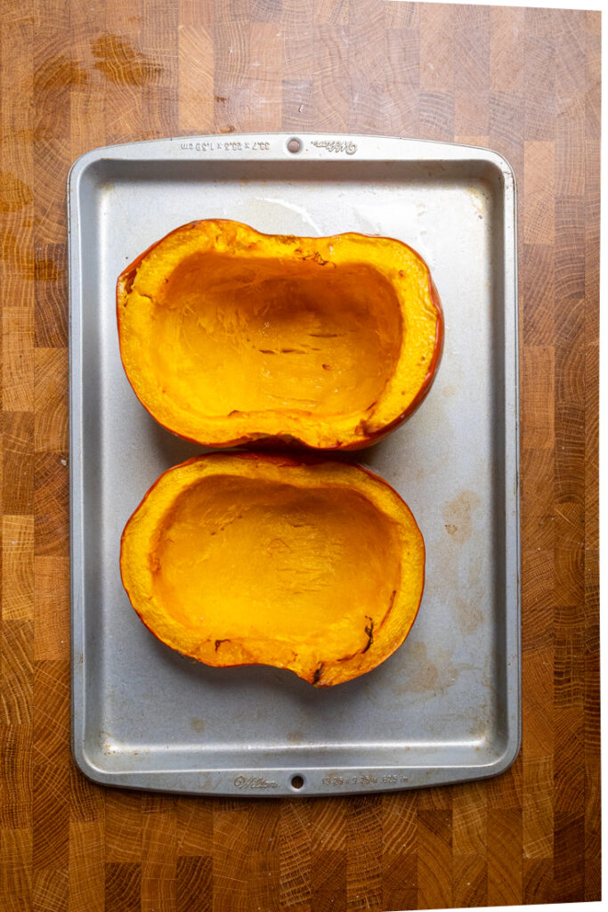 Two halves of Roasted Pumpkin on a tray cooked.