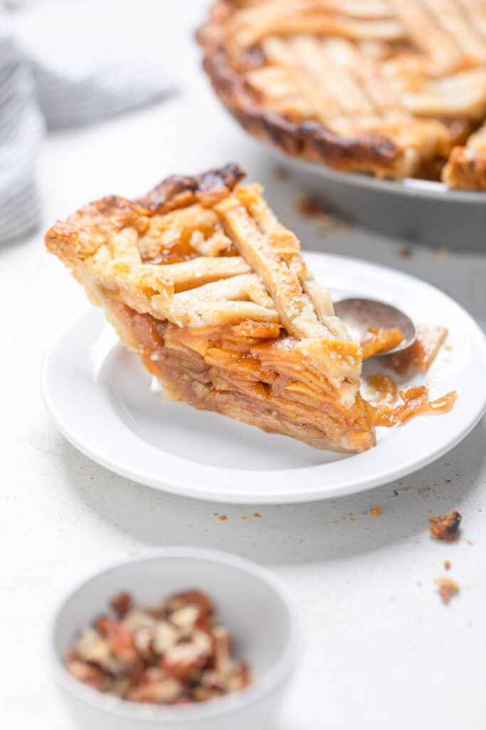 A thick slice of vegan caramel apple pie on a plate.