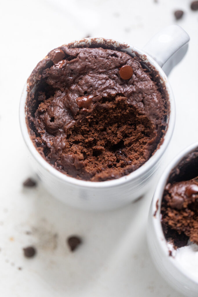 vegan chocolate mug cake with a spoonful missing.