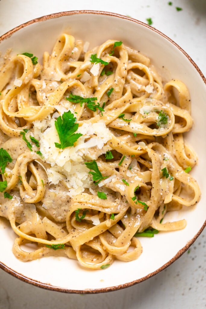 A bowl of Vegan one pot creamy garlic parmesan pasta top with parsley. 