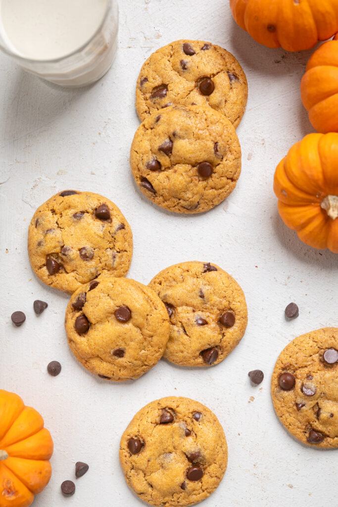 Vegan pumpkin chocolate chip cookies on a white table.