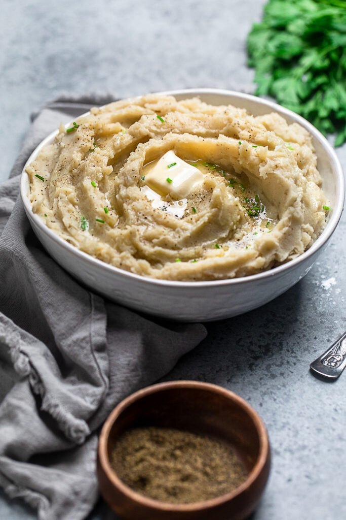 Vegan mashed potatoes with gravy in a white bowl.