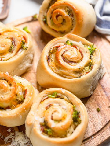 Vegan Ham and Broccoli Cheese Rolls on a wooden board.