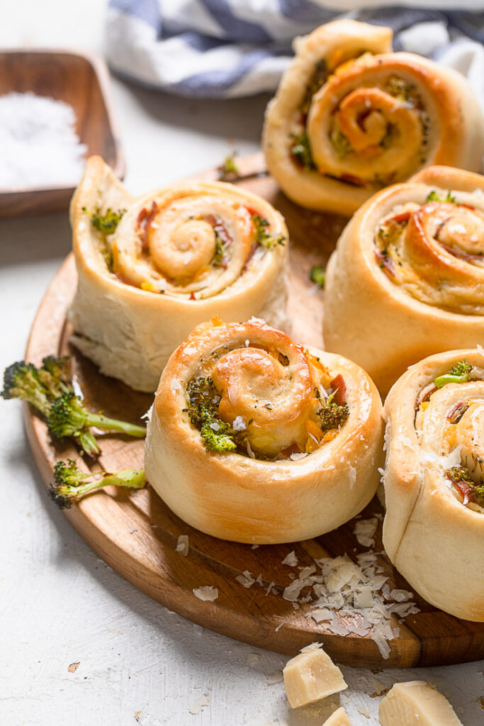 A tray of Vegan Ham and Broccoli Cheese Rolls on a wooden board.