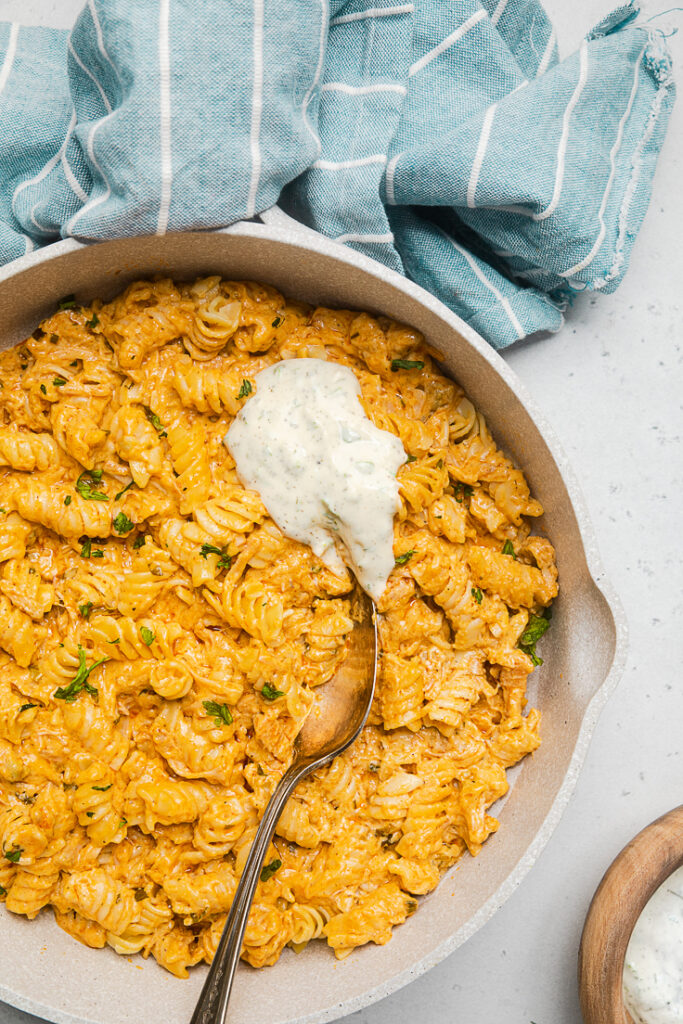 A serving dish of buffalo vegan chicken pasta with ranch dressing.
