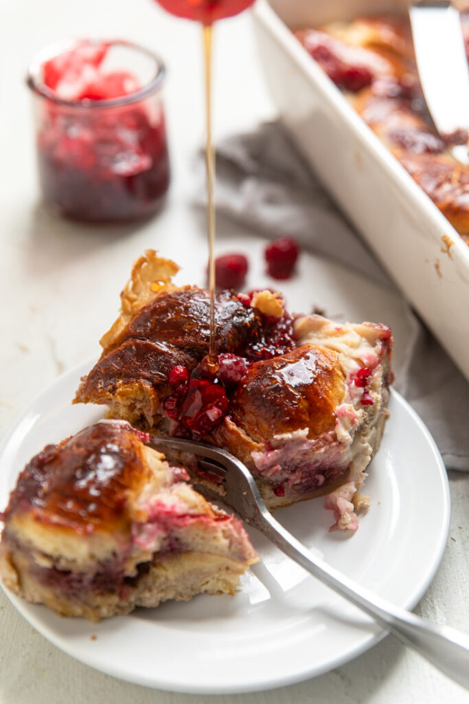 Slices of Raspberry Vegan Crescent French Toast Casserole on a plate with syrup drizzle.