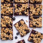 A batch of Vegan blueberry breakfast bars cut into squares.