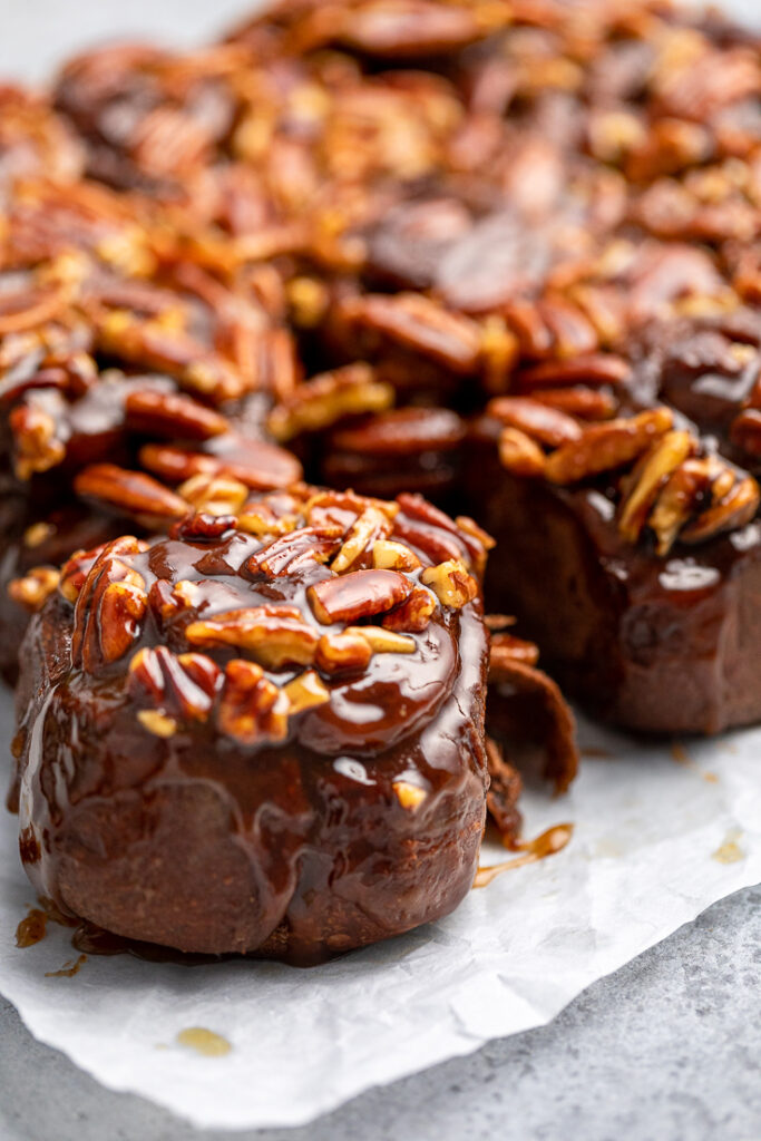A Vegan Chocolate Sticky Bun pulled away from the batch with caramel pecan topping.