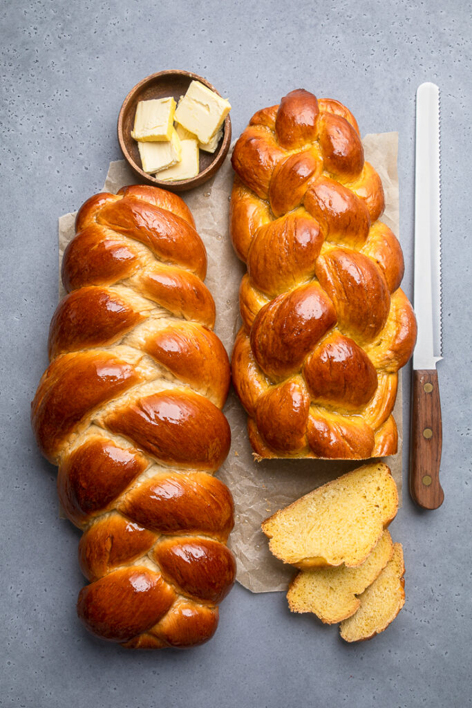 two vegan challah bread loaves with slices out of one.