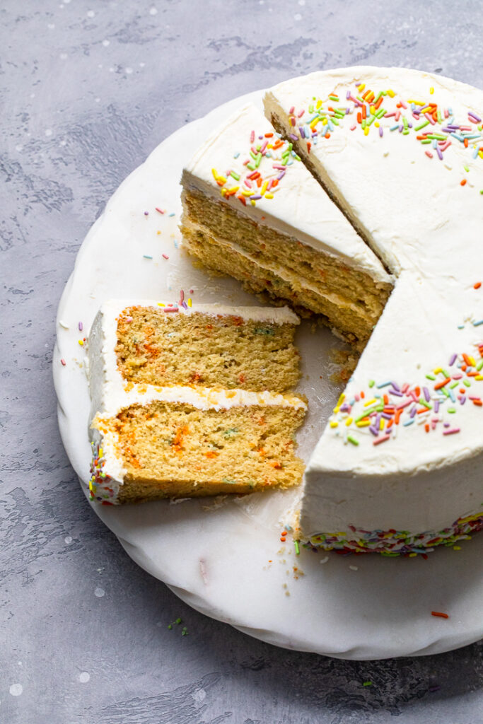 Double layered vegan vanilla birthday cake with slices.