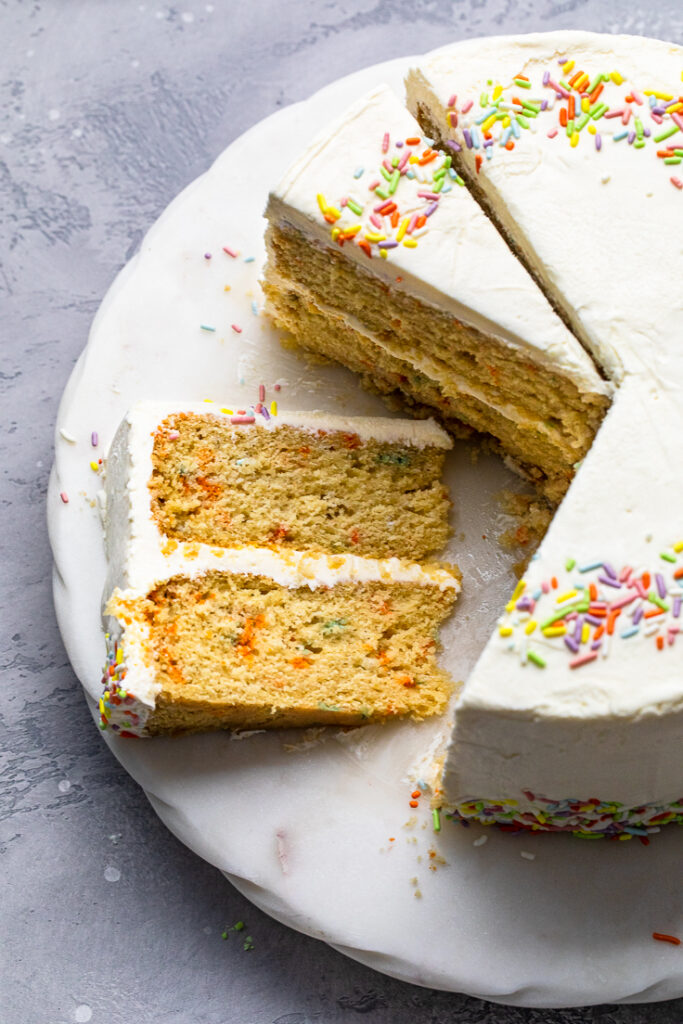 Vegan vanilla birthday cake slice with sprinkles.