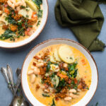 A bowl of Vegan zuppa Toscana topped with fresh herbs.