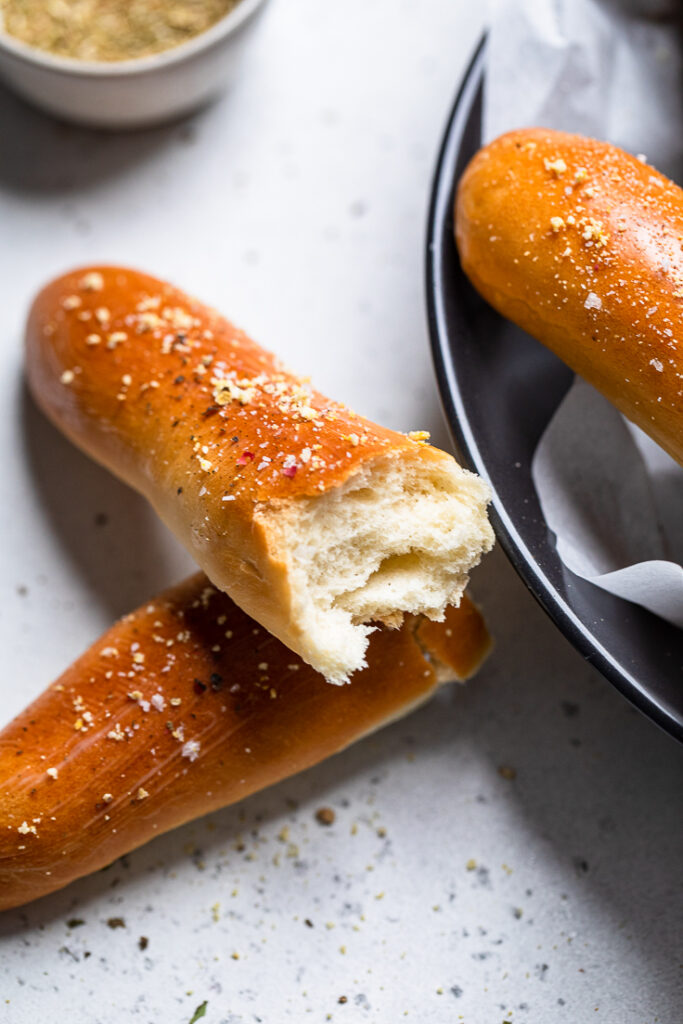 A vegan breadstick halved to show inside fluffy texture.