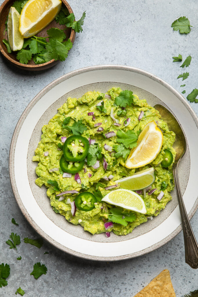 A bowl of fresh guacamole with Jalapenos and red onion.