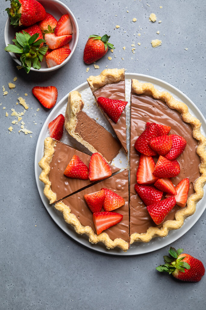 a serving plate of No Bake vegan chocolate pie with half sliced and half not sliced.