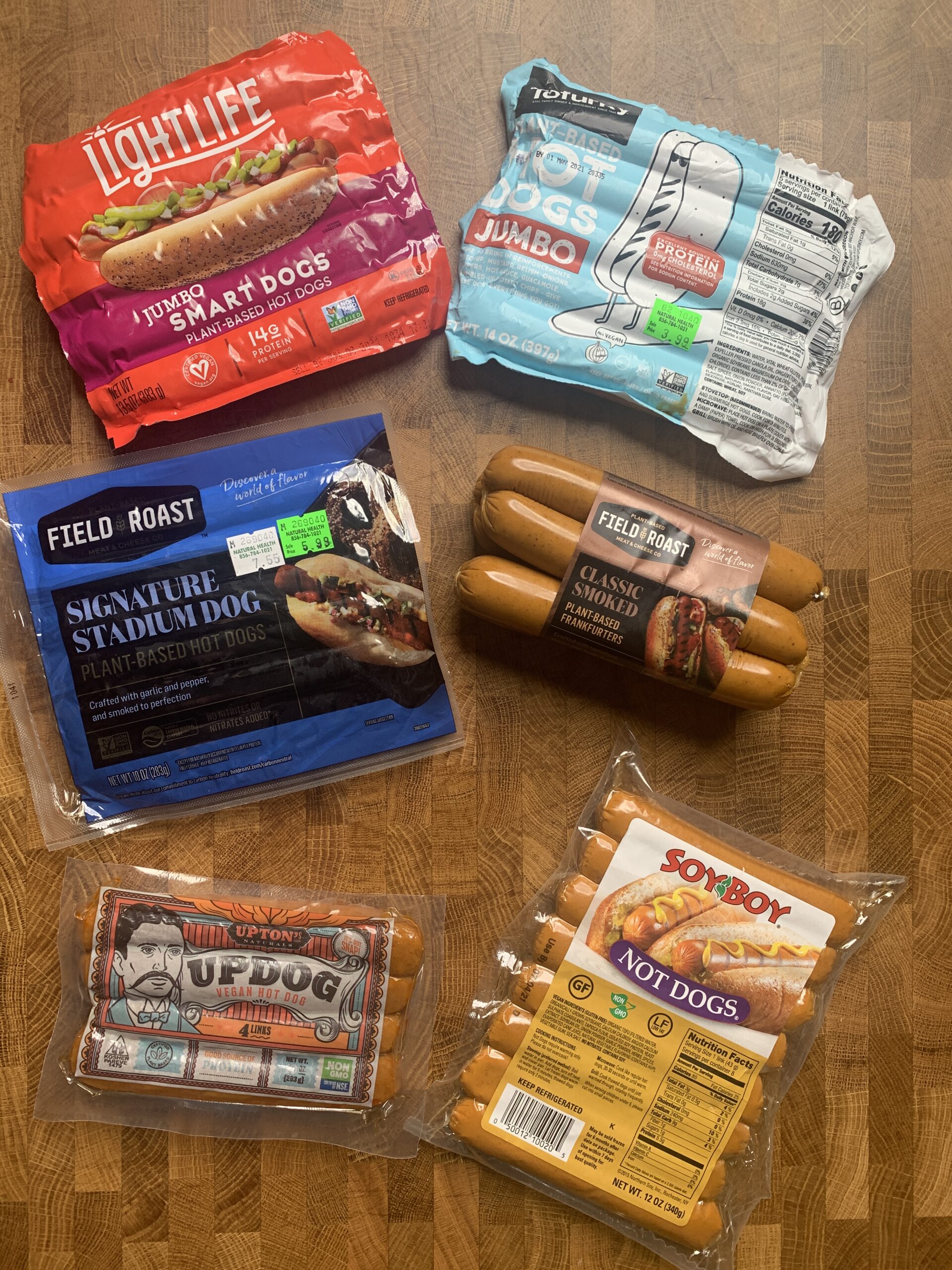 A table of vegan hotdogs packages from different brands.