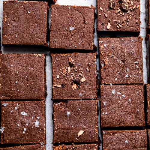 Tray of No Bake Vegan Chocolate Fudge cut into squares with flakey salt and chocolate shavings.