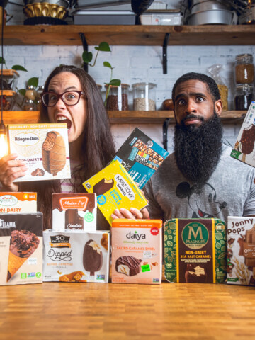 A couple posing behind a table of vegan ice cream bars packages.