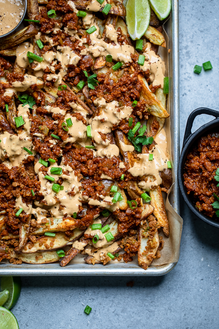A tray of easy vegan chili cheese fries with extra vegan meat on the side.