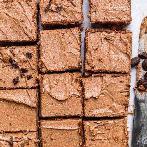 Squares of Vegan chocolate mousse fudge bards with chocolate chips cut.
