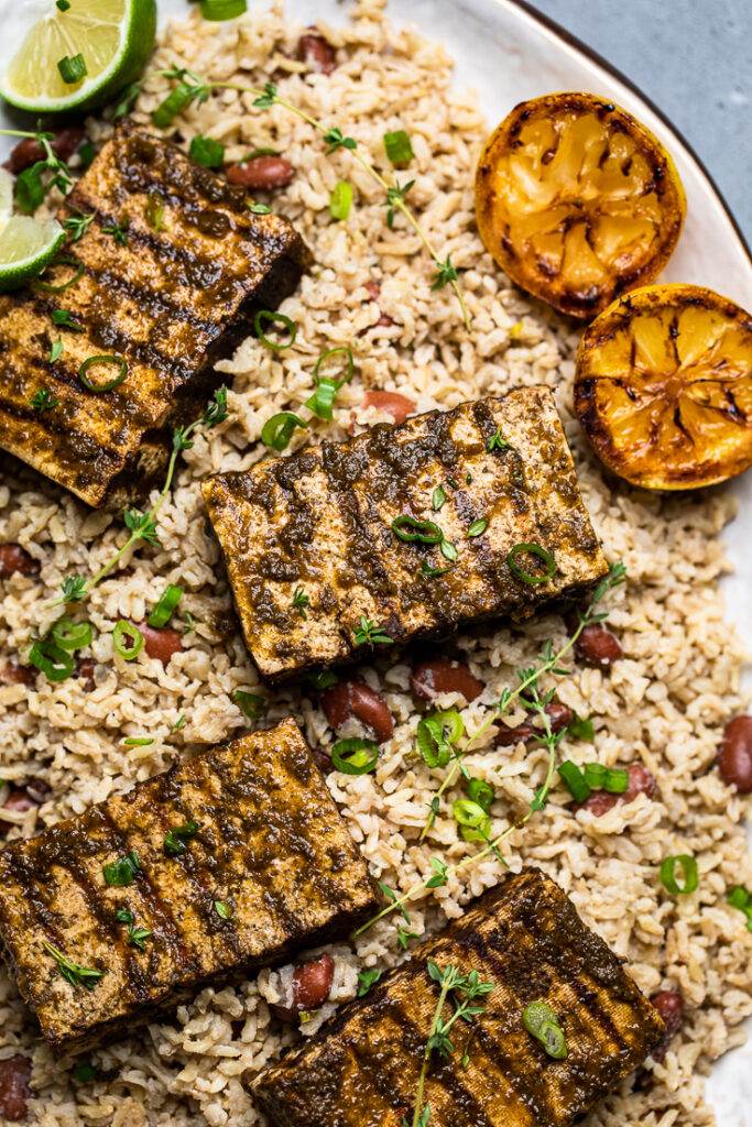 Three slices of authentic Jamaican jerk tofu over rice and peas. 