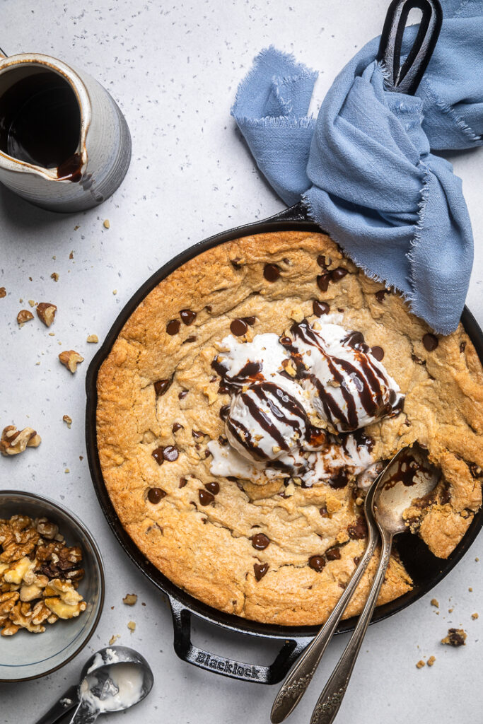 A large Chocolate chip cookie skillet with vanilla ice cream and chocolate drizzle. 