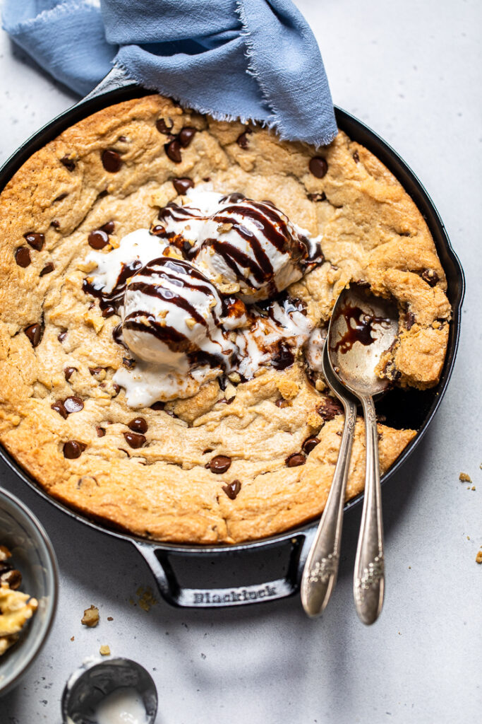 Vegan chocolate chip cookie skillet with vanilla ice cream and chocolate drizzle. 