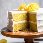 A two-layered Vegan Lemon Cake with cream cheese frosting and spiraled fresh lemons on top.