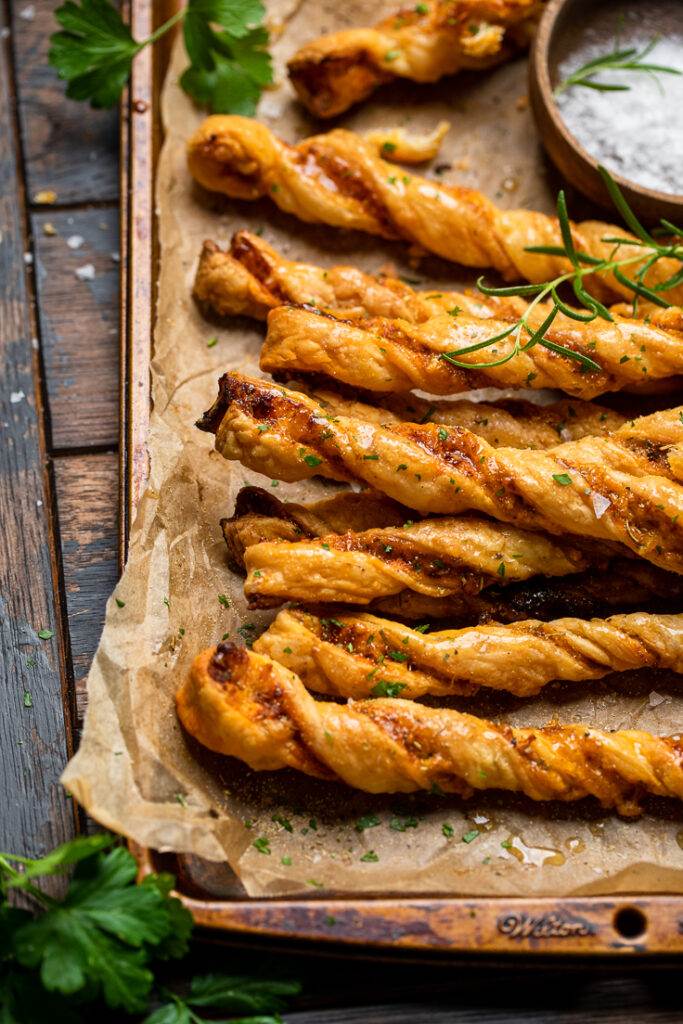 A parchment lined tray of Brown Sugar Sweet and Savory Vegan Cheesy Garlic Twists.