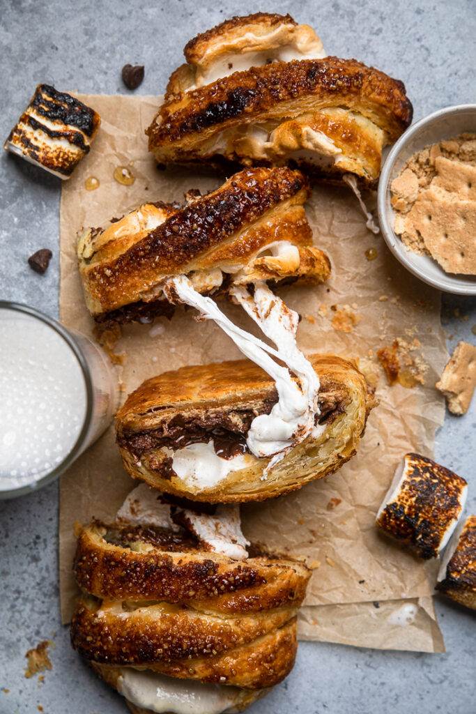 Slices of toasted vegan smores pastry with gooey marshmallow pulling out of two pieces.