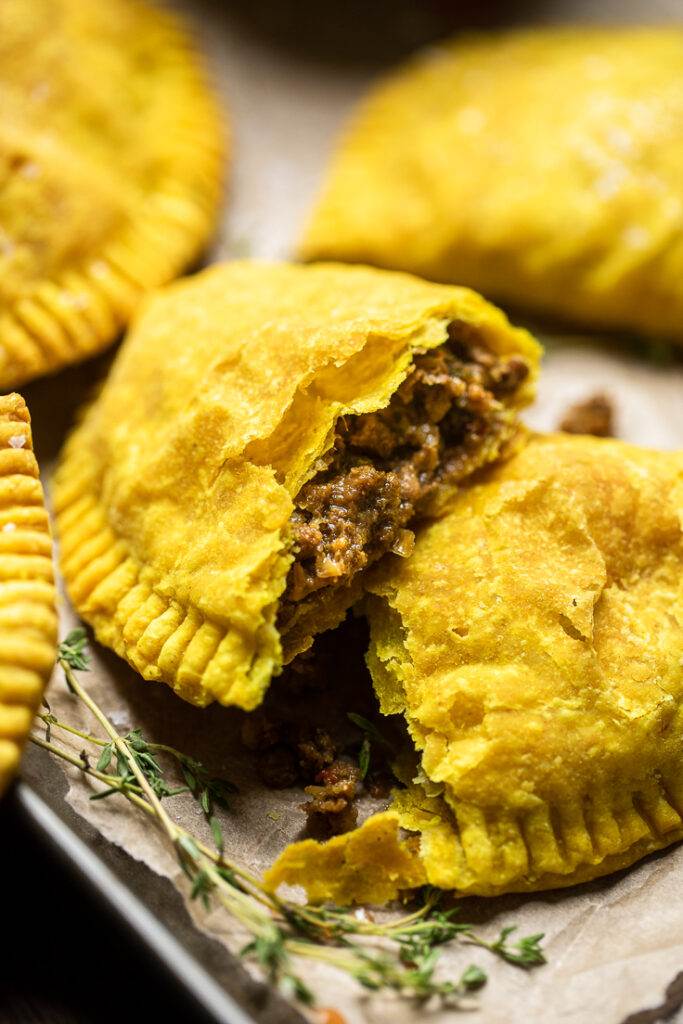 A halved Vegan Jamaican Beef Patty to show meaty filling texture. 