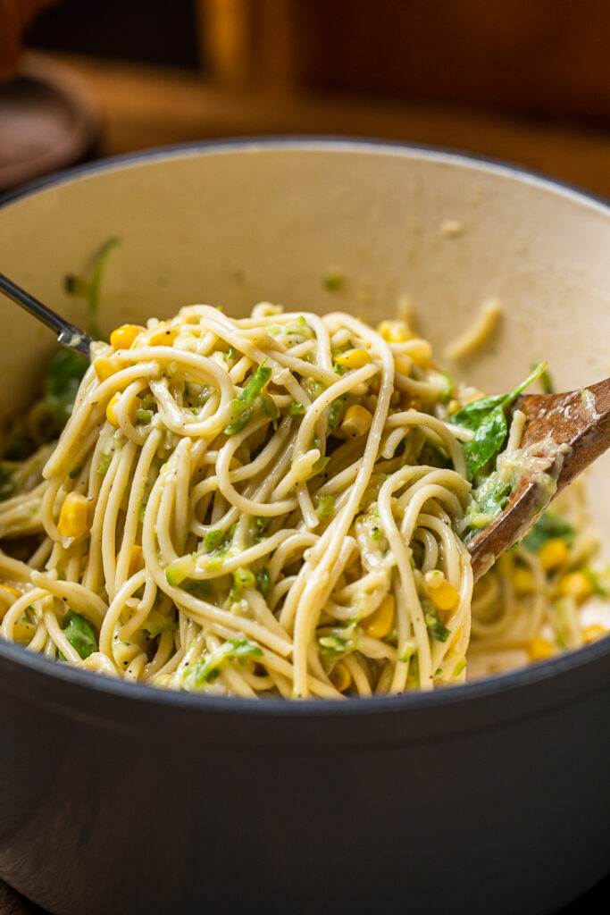 A large spoonful of creamy vegan zucchini pasta and sweet corn.