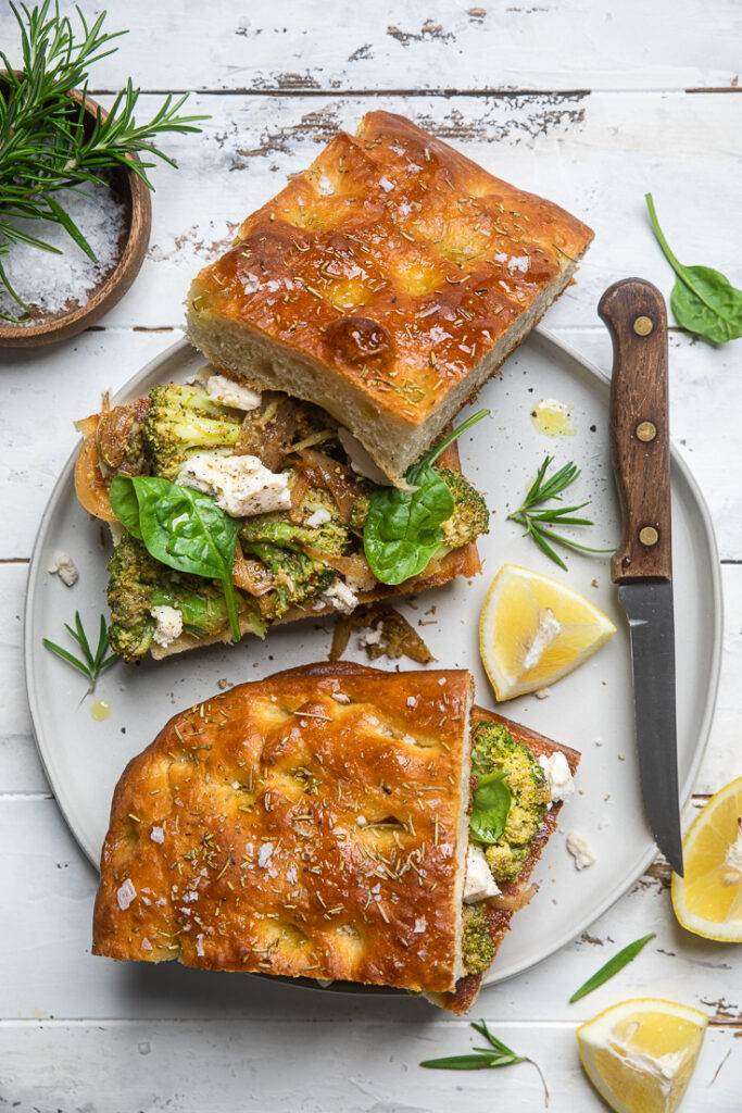 A plate with two no knead rosemary focaccia broccoli and mozzarella sandwiches.