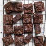 cut squares of the best vegan brownies on a wire baking rack.