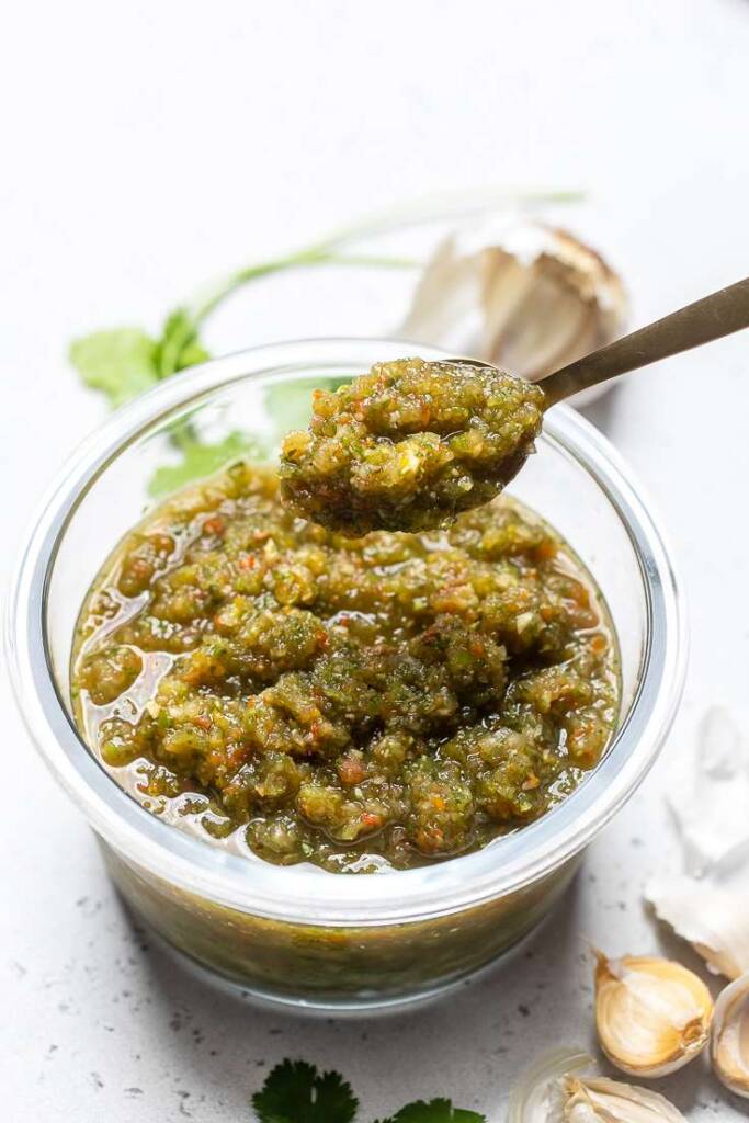 A small bowl of Puerto Rican Sofrito with a spoonful of mixture over it.