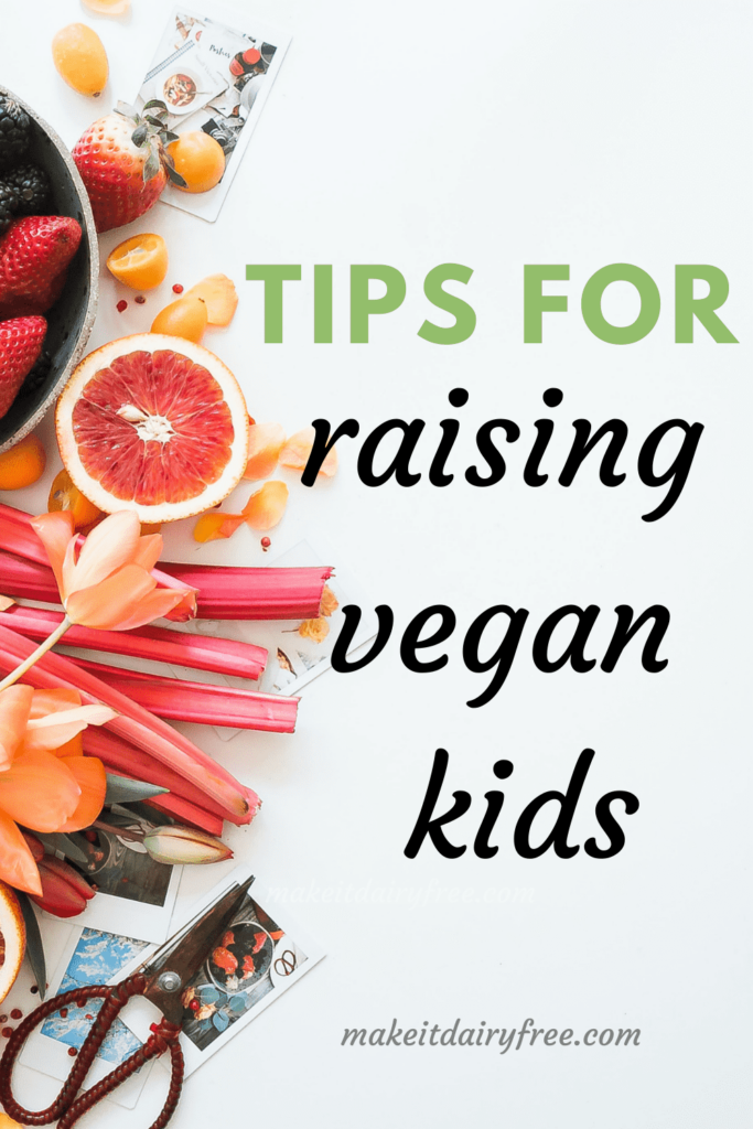 a tablescape of fruit with the words tips for raising vegan kids overlayed.