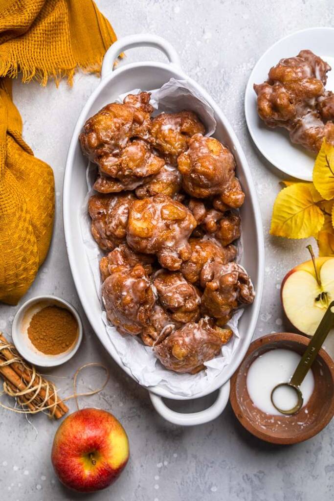 A white oval casserole dish of no yeast vegan apple fritters. 