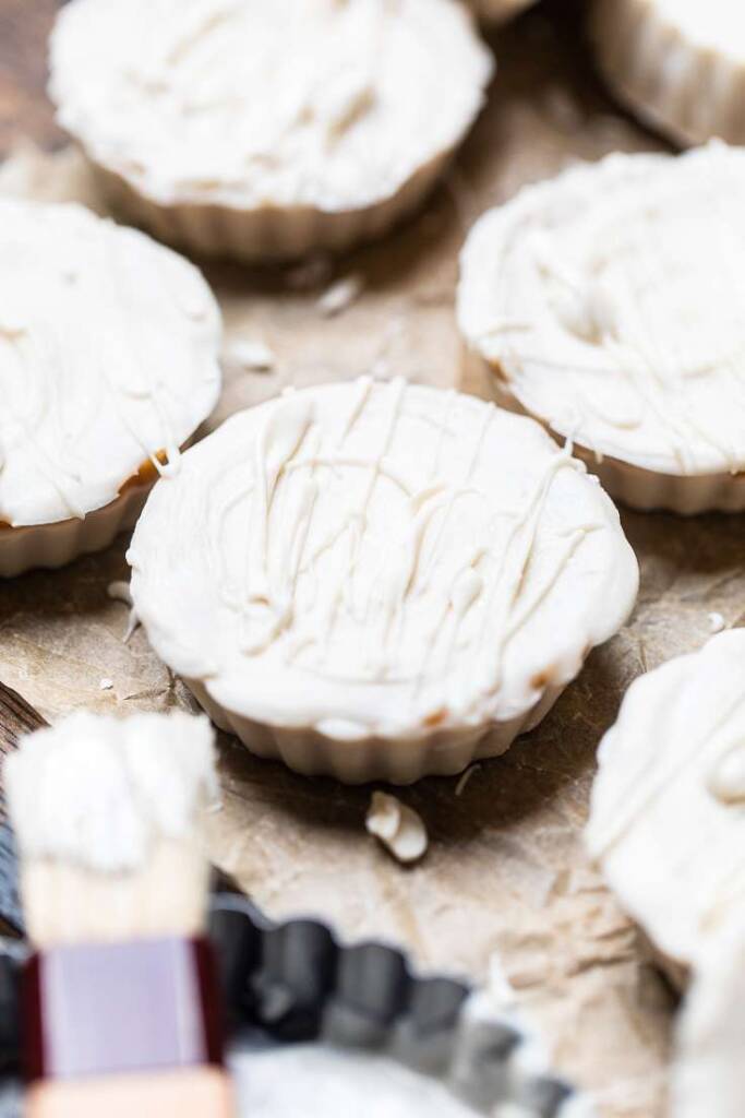 A vegan white chocolate peanut butter cup with more white chocolate drizzled. 