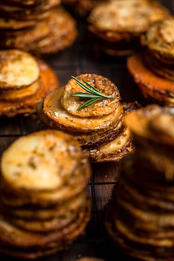 a group of crispy cheesy and herb vegan potato stacks. 